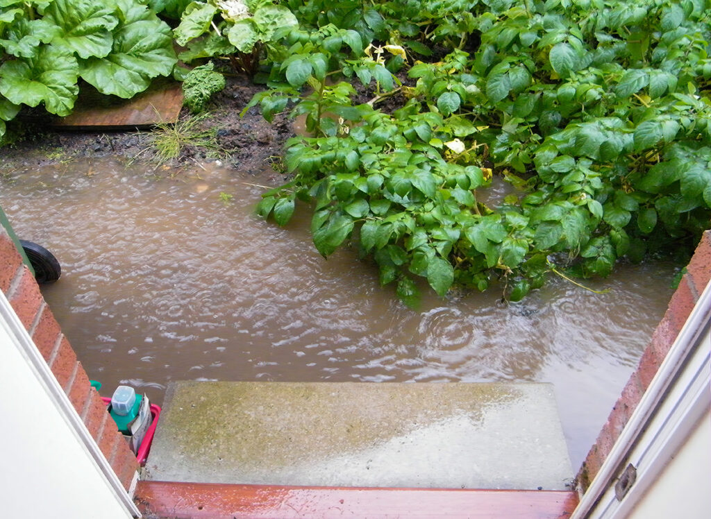 Looking from House Door to Flooded Garden During Heavy Rain Shower